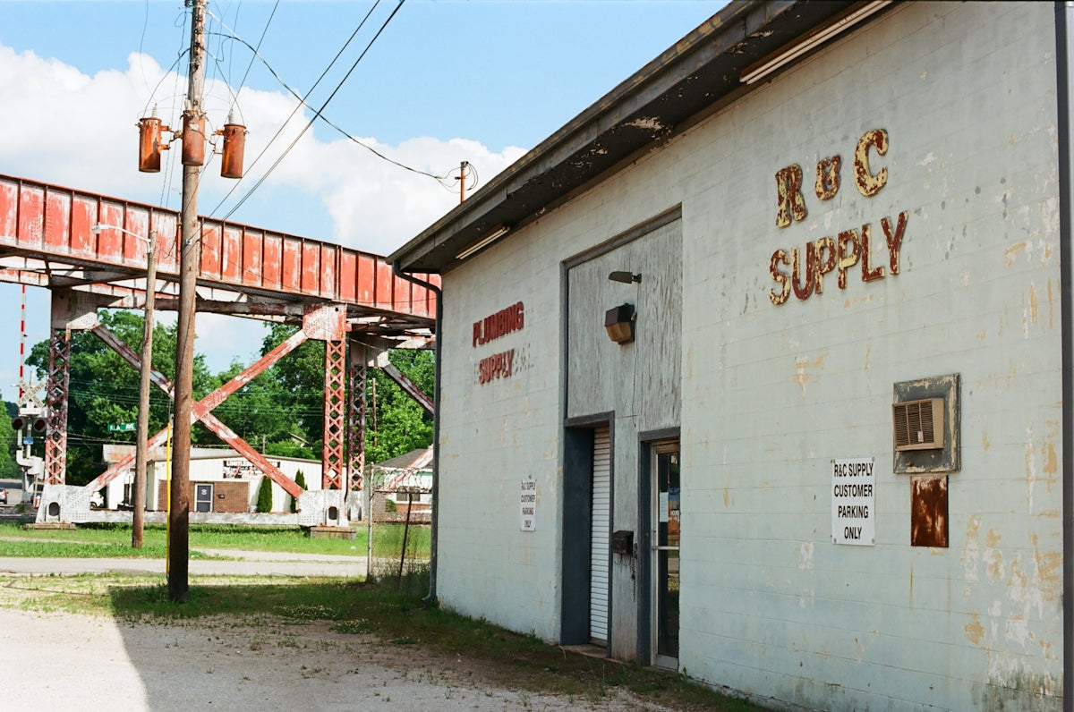 White rvs supply building next to a rusty industrial gantry.